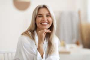 blonde woman in white silky bathrobe smiling