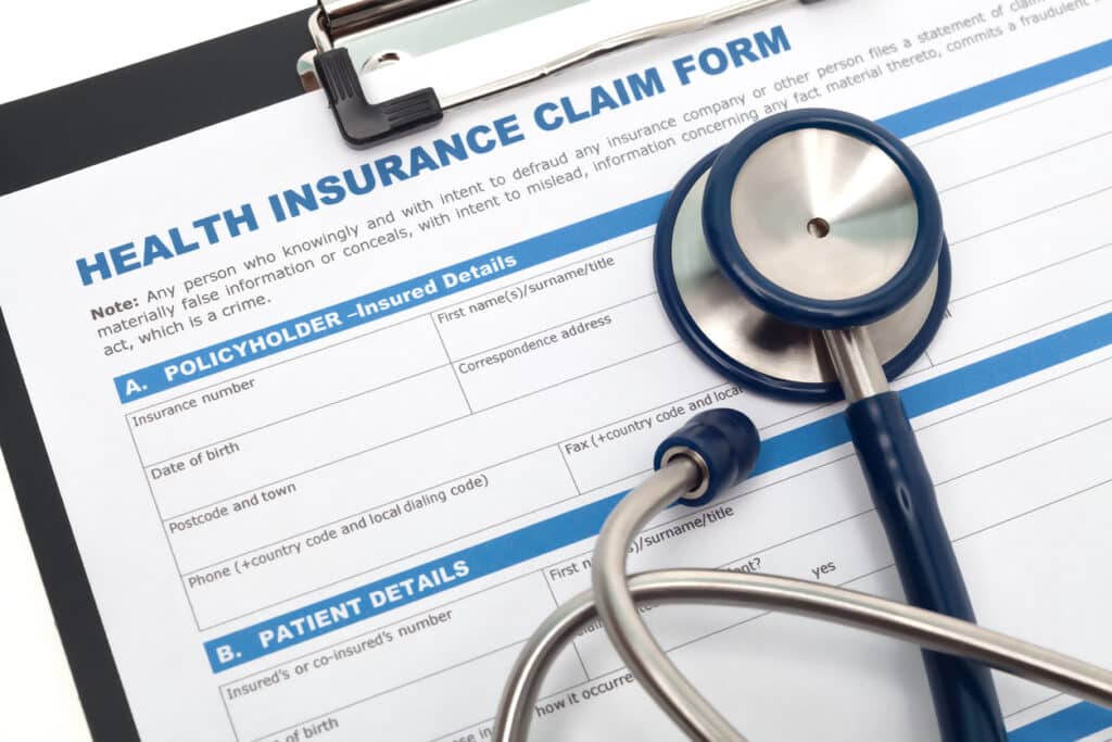 Patient looks at health insurance form on a clipboard.